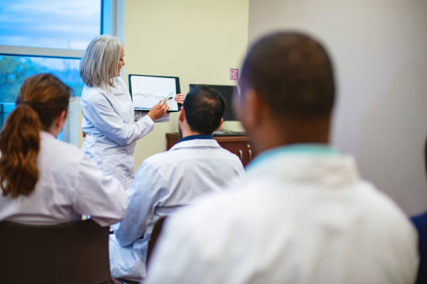 istock Female Healthcare Instructor with Multiracial Group Clinical Classes and Training Medical Staff in Western USA Photo Series 1454092230