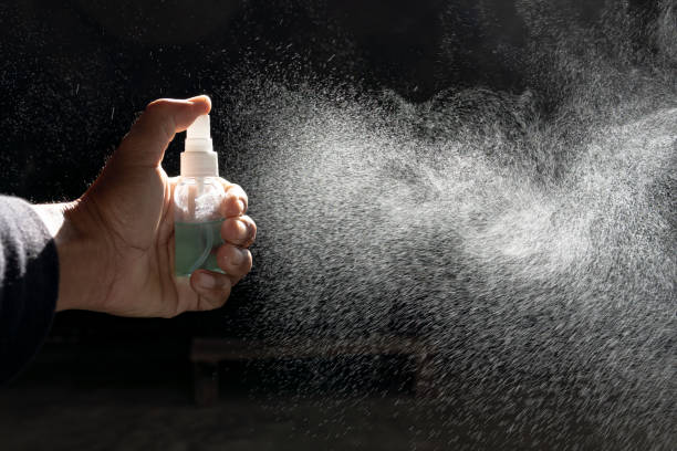 istock Cleaning spraying antibacterial sanitizing spray bottle disinfecting against COVID-19 spreading wearing medical . Sanitize surfaces prevention in hospitals and public spaces. 1454094618