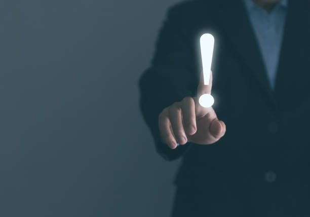 istock Businessman hand touching white exclamation mark business development ideas error warning 1454095868