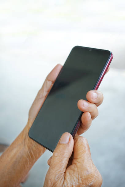 istock old  asian woman's hand  holding a smart phone 1454099602