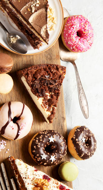 istock Table with various cakes, cookies, donuts and coffe cups on light background. 1454100085
