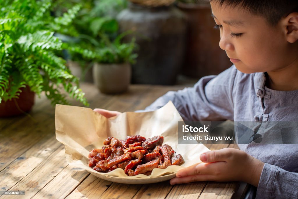 A cute little boy was tasting delicious barbecue 6-7 Years Stock Photo
