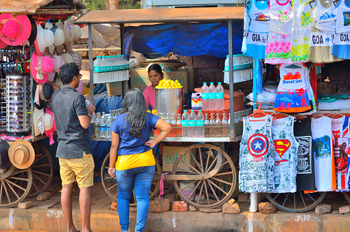 Goa, India - January 24, 2019: People buying water bottle from a roadside stall.