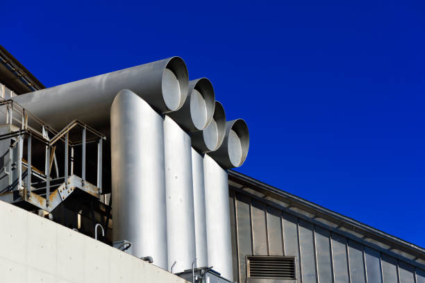 Air ducts in a large building against clear sky with copy space.