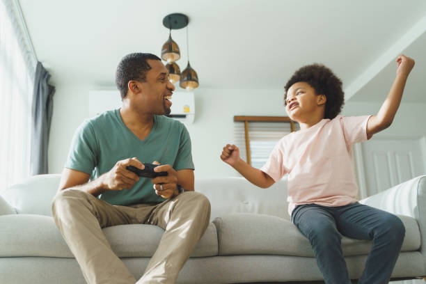 istock African Father and son playing console games 1454109798