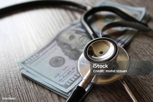Stethoscope And Money On Wooden Table Stock Photo - Download Image Now - Healthcare And Medicine, Expense, Price
