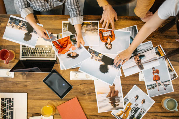 uma equipe escolhendo uma capa de revista - casual teamwork journalist editor - fotografias e filmes do acervo