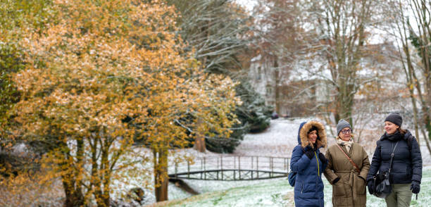 istock Mother has a conversation with her two daughters while walking outside in a park during a snowy day 1454121719