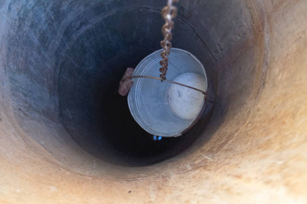 istock Old well with iron bucket on long forged chain for clean drinking water 1454122843