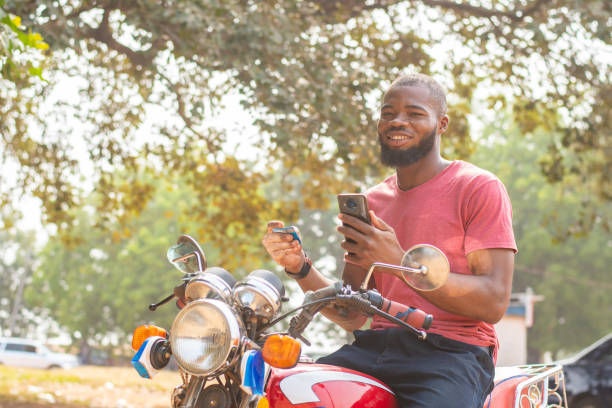 istock Black man on a motorcycle with a smartphone 1454122926