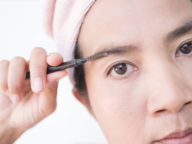 Woman Draw eyebrows Eyebrow Brush Close up Woman Draw eyebrows Eyebrow Brush Close up,Girl Shaping brows Brushing Eyebrows,Portrait Makeup Face Beauty Cosmetic,Authentic Skin Tan and Black Eyes Asian Thailand. woman mascara smudged stock pictures, royalty-free photos & images