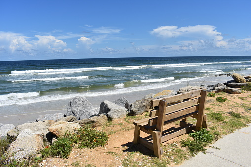 A daylight shot of a bench with an ocean view in Marineland Florida.
