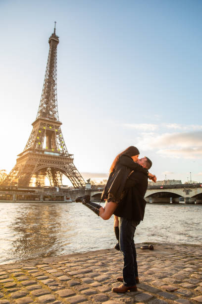 vertikale aufnahme des glücklichen paares beim fotografieren mit dem eiffelturm im hintergrund, paris, frankreich - paris france eiffel tower love kissing stock-fotos und bilder