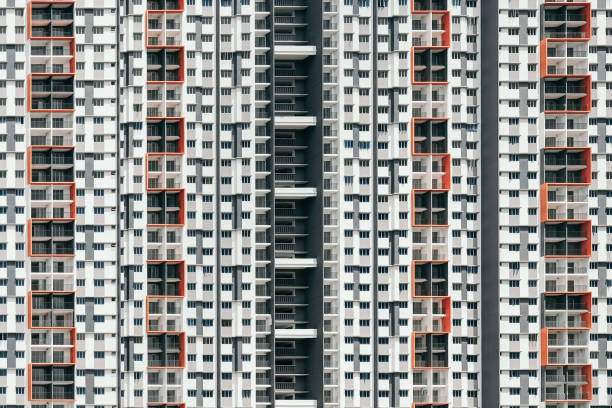 istock Modern white high-rise building with orange and black peaces on windows 1454127158