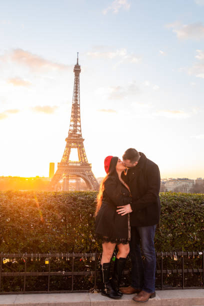 vertikale aufnahme des glücklichen paares beim fotografieren mit dem eiffelturm im hintergrund, paris, frankreich - paris france eiffel tower love kissing stock-fotos und bilder