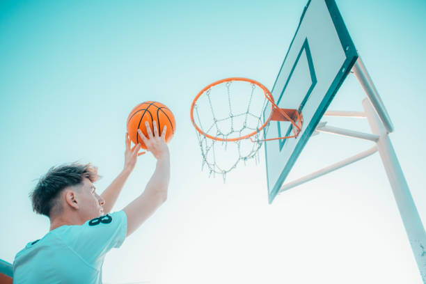 istock Attractive young Spanish guy throwing a ball in a basketball hoop 1454127976