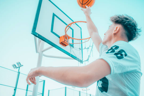 istock Pretty caucasian boy playing basketball on a playground 1454128016