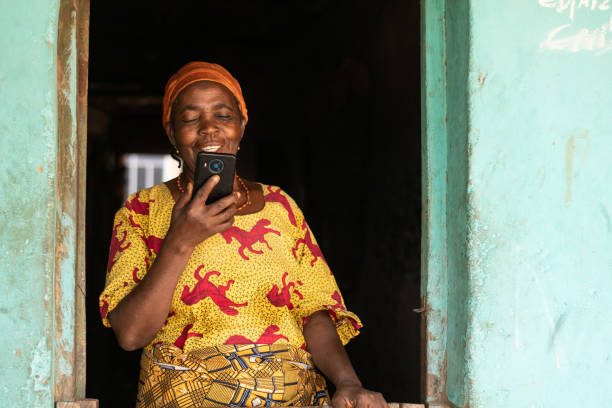 Smiling elderly african woman using her mobile phone