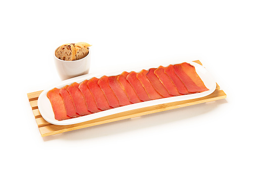 Closeup shot of tuna fillet with crackers on white background