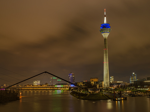 A mesmerizing view of the illuminated Rhine tower on the river with Dusseldorf in the background