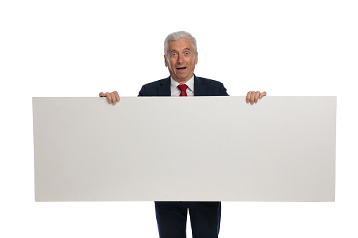 old businessman feeling shocked and holding a white billboard