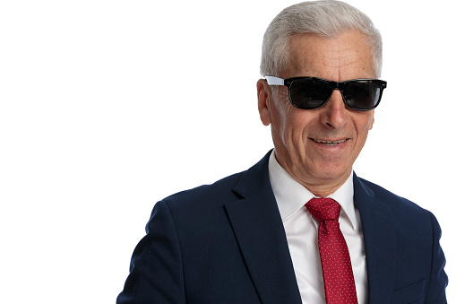 portrait of an happy businessman in his 60s wearing sunglasses and smiling at the camera