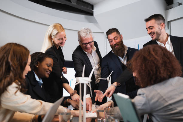 istock Multiracial businesspeople during a meeting pointing at the same direction at document on the desk. Unity of purpose, cooperation and achievement concept. 1454134920