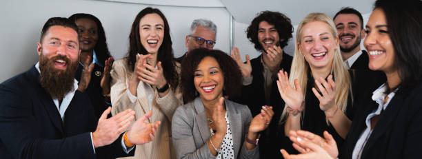 istock Diverse ethnicity group of colleagues clapping hands congratulating and exult for good results. Horizontal banner or header. 1454134987