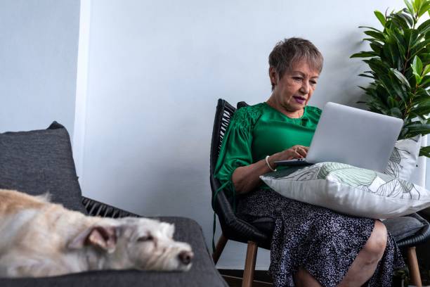 istock Old Hispanic female working from home in front of her laptop 1454135380