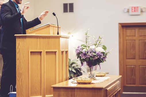 A view of a pastor preaching on the pulpit in the church