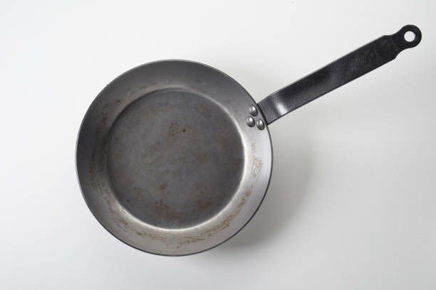istock Top view of an empty small old aluminum frying pan with a handle on white background 1454138433