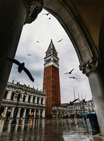 A low angle shot of beautiful architecture of the Tower of San Marco through the arch in Venice, Italy