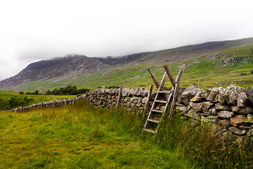 A wooden ladder over a dry stone wall in Snowdonia National park