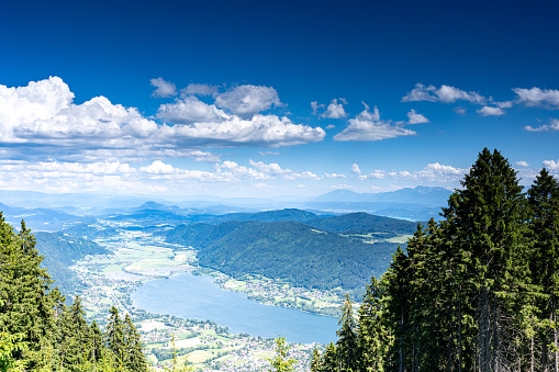 People standing at a viewpoint on San Salvatore mountain overlooking Lake Lugano.