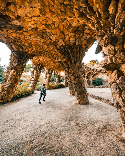 frau, die tagsüber im unglaublichen park güell in barcelona spazieren geht - parc guell stock-fotos und bilder