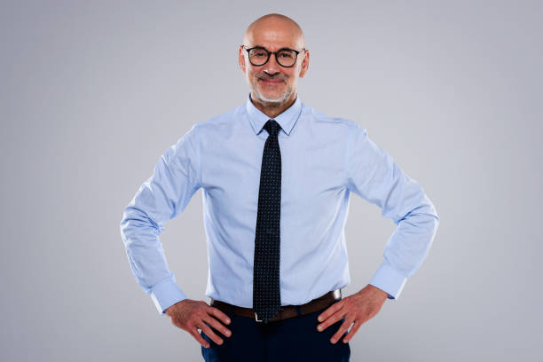 istock Confident businessman with hands on hips standing at isolated background 1454140291