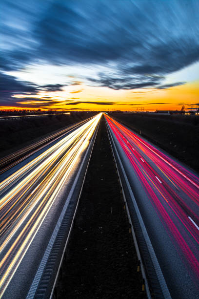 istock Highway with white and pink illuminations at sunset 1454140695
