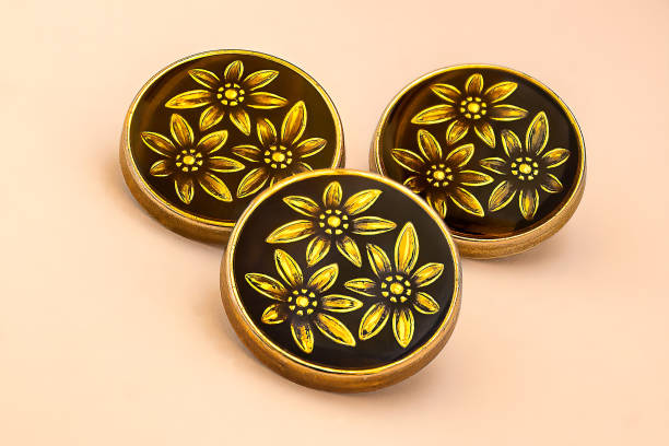 istock Three ornated clothing buttons on a peach background 1454141964