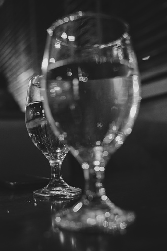 A vertical shot of a glass full of water on a table in a cafe