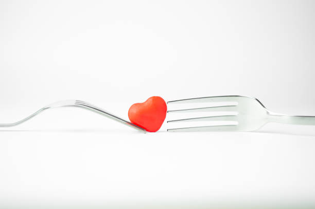 istock Closeup of a small red heart between two forks. 1454143418