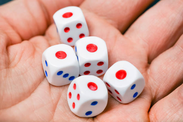 istock Close up view on dice on the palm. Yahtzee is a dice game. All five dice the same number - one. 1454144202