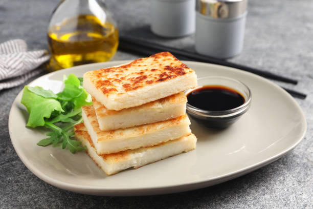 istock Delicious turnip cake with arugula and soy sauce served on grey table 1454145769