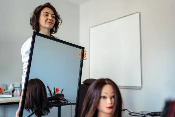 Photo of A Student working as a hairdresser with a dummy