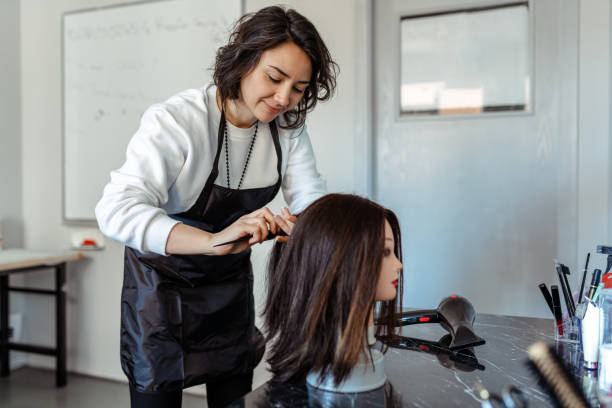 ein student arbeitet als friseur mit einem dummy - beauty spa scissors hairstyle beautician stock-fotos und bilder
