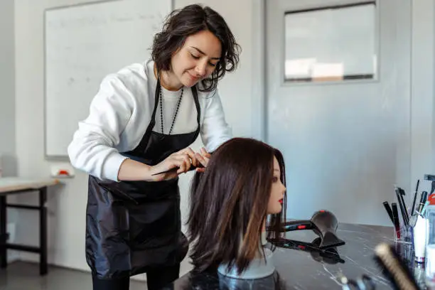 Photo of A Student working as a hairdresser with a dummy