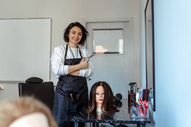 istock A Student working as a hairdresser with a dummy 1454150272