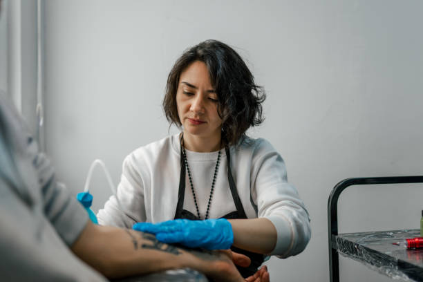 istock Tattoo artist drawing in her studio with latex 1454150461