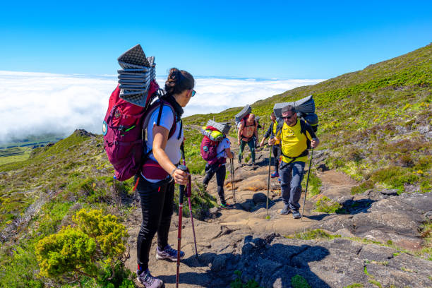 people starting on an organized basis with camping tents going uphill on the island of Pico, Azores archipelago stock photo