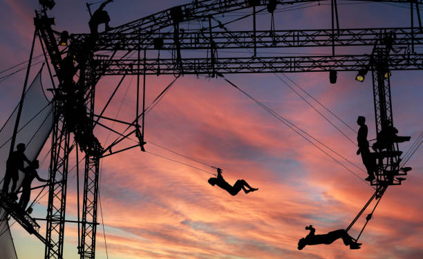 sylwetki akrobatów trapezowych - acrobatic activity zdjęcia i obrazy z banku zdjęć