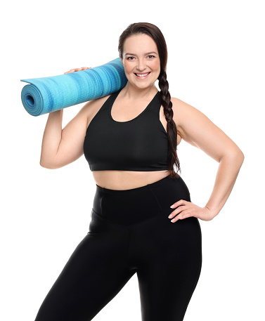 Happy overweight woman with yoga mat on white background